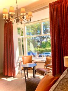 uma sala de estar com uma janela, uma mesa e cadeiras em White Gable em Scarborough