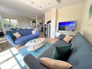 a living room with a blue couch and a table at Ferienhaus Svantovit - exklusives Ferienhaus mit Sauna, Whirlpool und Kamin in Putgarten