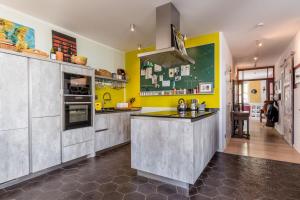 une cuisine avec un comptoir et un mur jaune dans l'établissement Super Host im Bremer Viertel., à Brême