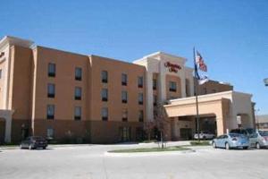 un gran edificio con coches estacionados en un estacionamiento en Hampton Inn Garden City, en Garden City