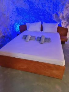 łóżko z 2 poduszkami w pokoju w obiekcie Anassa Cave by Estia w Heraklionie