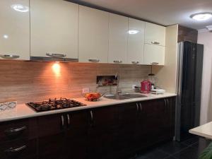 a kitchen with white cabinets and a sink and a stove at Lileo in Tsalka +16 photos