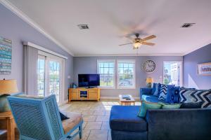 a living room with a blue couch and a ceiling fan at Gulf Sunset View on Deep Water Canal minutes from Weeki Wachee Springs in Hernando Beach