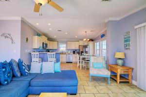 a living room with a blue couch and a kitchen at Gulf Sunset View on Deep Water Canal minutes from Weeki Wachee Springs in Hernando Beach