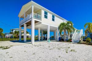 a house on the beach with palm trees at Gulf Sunset View on Deep Water Canal minutes from Weeki Wachee Springs in Hernando Beach