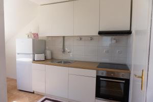 松博爾的住宿－Apartment Sunshine，白色的厨房配有水槽和冰箱