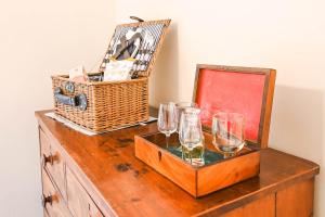 uma mesa com copos de vinho e um cesto em Morningside Cottage em Tenbury
