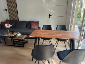 un salon avec une table, des chaises et un canapé dans l'établissement Idyllischer Bungalow am Badesee, à Reuthen