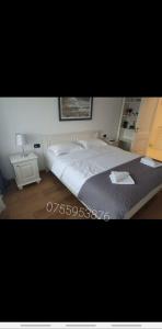 een slaapkamer met een groot bed en een nachtkastje bij Apartament Luxury in Vişeu de Sus