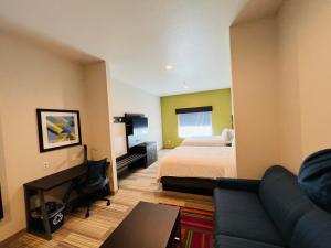 um quarto de hotel com uma cama e um sofá em Holiday Inn Express & Suites Salinas, an IHG Hotel em Salinas