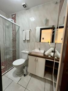 uma casa de banho com um WC, um lavatório e um chuveiro em Pousada Cinnamon em Canela