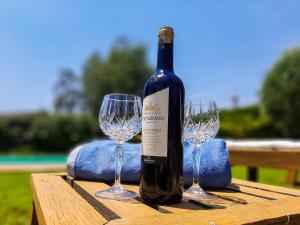eine Flasche Wein auf einem Tisch mit zwei Weingläsern in der Unterkunft Casa Jazmín in Arriate
