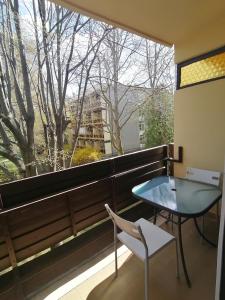 einen Balkon mit einem Tisch, einem Stuhl und einem Fenster in der Unterkunft Leila Apartman in Balatonfüred