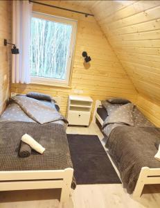 een kamer met 2 bedden in een blokhut bij Świerkowisko cisza las plaża blisko in Ostróda
