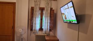 a flat screen tv on a wall with a window at Alojamiento Turístico El Pantano de Cazorla in Coto Ríos