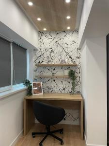 a desk with a chair in front of a wall at Palas Loft in Iaşi