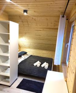 pokój z łóżkiem w drewnianym domku w obiekcie Świerkowisko cisza las plaża blisko w Ostródzie