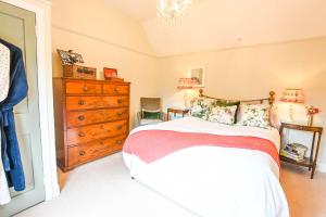 ein Schlafzimmer mit einem großen Bett und einer Kommode in der Unterkunft Morningside Cottage in Tenbury