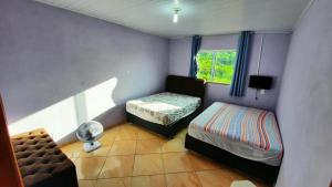 a small bedroom with a bed and a window at Casa Santos - Pirenópolis in Pirenópolis