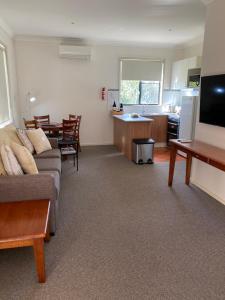 a living room with a couch and a kitchen at Beautiful Villa in the heart of the Hunter Valley in Pokolbin