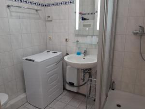 a white bathroom with a sink and a toilet at gemütliche kleine Ferienwohnung in Chemnitz