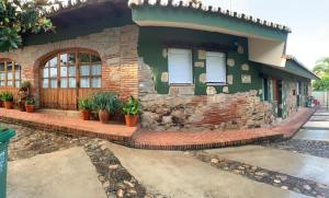 une maison avec des plantes devant elle dans l'établissement CASA RURAL EL OLIVO, à Logrosán
