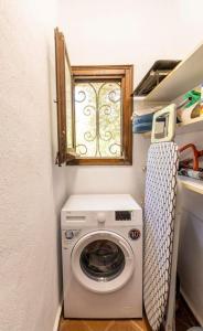 uma máquina de lavar roupa num pequeno quarto com uma janela em Villa Ventisca em Platja  d'Aro