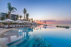 una piscina con sillas y sombrillas y el océano en Villa La Valencia Beach Resort & Spa Los Cabos, en San José del Cabo