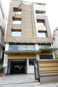 a building with a sign on the front of it at Marshall The Hotel in Ahmedabad