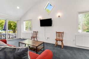 sala de estar con TV, sillas y mesa en Blues Views, en Castleton
