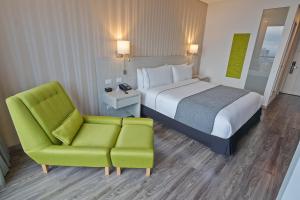 Pokój hotelowy z łóżkiem i krzesłem w obiekcie Sonesta Hotel Ibagué w mieście Ibagué