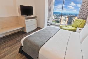 a hotel room with a bed and a television at Sonesta Hotel Ibagué in Ibagué