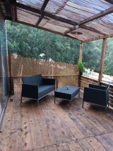 a patio with two chairs and a table on a wooden deck at U San Francescu Maisonette Modulaire Type studio in Volpajola