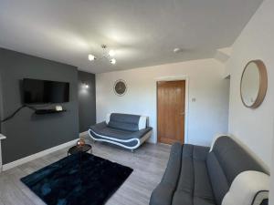 a living room with a blue couch and a television at Cosy, Modern Home Near BHX, NEC and City Centre in Birmingham