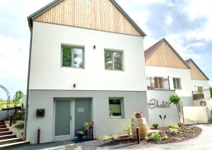 a white house with a brown roof at Weinberg Chalets in Eisenberg an der Pinka