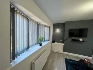 a living room with a large window and a television at Cosy, Modern Home Near BHX, NEC and City Centre in Birmingham