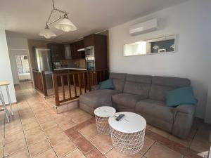 een woonkamer met een bank en 2 tafels bij Apartamento Niar in Playa Honda