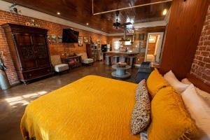 a bedroom with a large yellow bed and a kitchen at Bayou Chateau in New Iberia