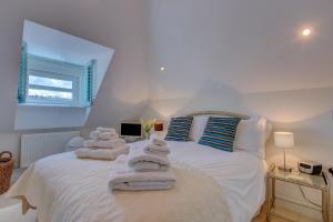 a bedroom with a white bed with towels on it at Celeste in Carbis Bay