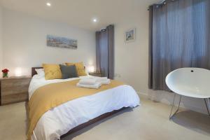 a bedroom with a bed and a table and a window at Ocean Gate in Carbis Bay