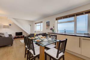 Atlantic Blue في Carbis Bay: غرفة طعام وغرفة معيشة مع طاولة وكراسي