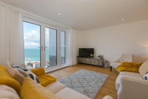 a living room with a couch and a large window at Beach View in St Ives