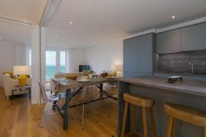 a kitchen with a table and chairs in a room at Beach View in St Ives