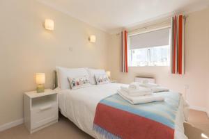 a bedroom with a bed with towels on it at Atlantic Blue in Carbis Bay