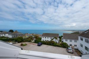 a view of a town with houses and the ocean at St Ives Bay View in Carbis Bay