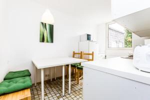 eine Küche mit weißen Arbeitsflächen und einem weißen Tisch in der Unterkunft Apartment Köln Weidenpesch in Köln