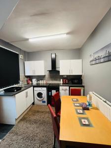 a kitchen with a table and a kitchen with white cabinets at APARTMENTS OF LIVERPOOL in Liverpool