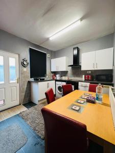 a kitchen with a wooden table and red chairs at APARTMENTS OF LIVERPOOL in Liverpool