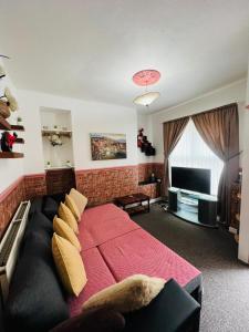 um quarto com uma grande cama vermelha e uma televisão em APARTMENTS OF LIVERPOOL em Liverpool
