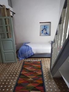 a room with a bed next to a stair case at RIAD MAROSKO in Essaouira